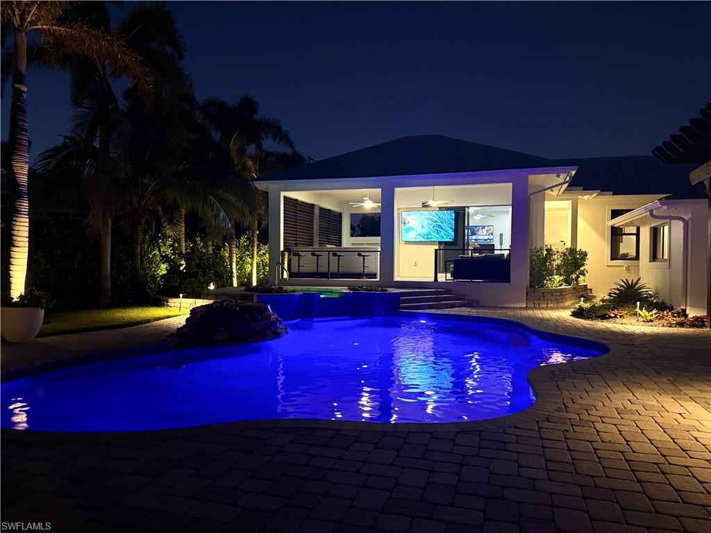 1555 Crayton Road Naples, FL 34102 - Photo 48 of 50 Pool at night with a gazebo, ceiling fan, a patio area, and exterior bar