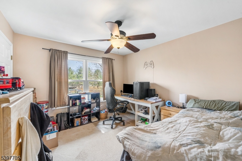 50 Blau Road Hackettstown, NJ 07840 - Photo 19 of 35 a bedroom with a bed a computer on a desk and a chandelier