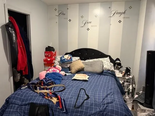 a bedroom with a bed and a flat tv screen on a dresser