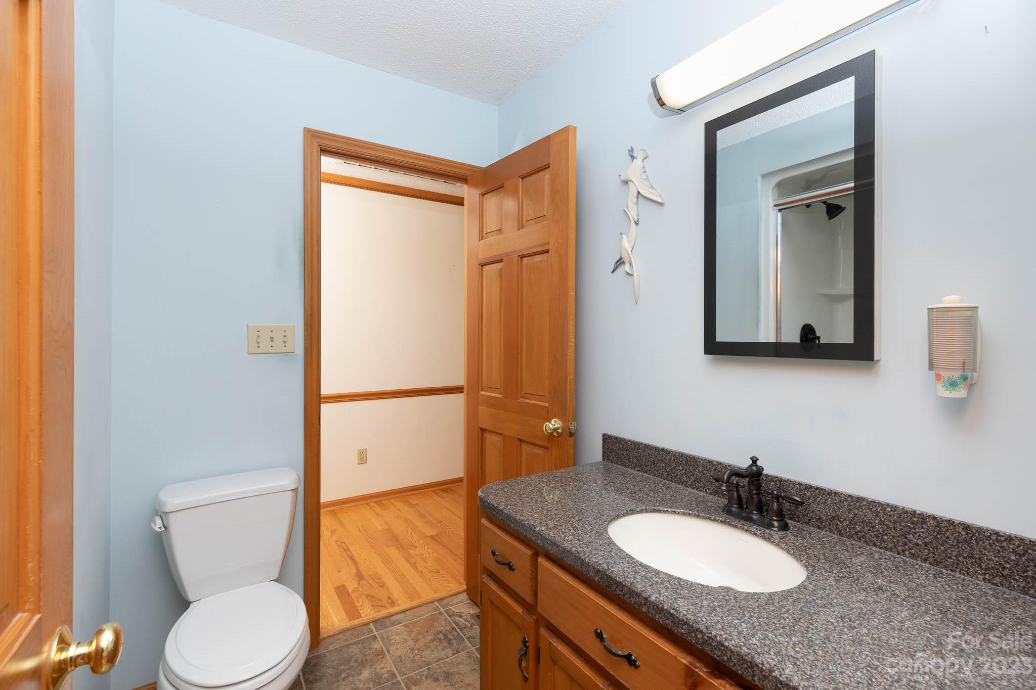 7869 Cherry Point Drive Denver, NC 28037 - Photo 15 of 38 a bathroom with a granite countertop sink toilet and shower