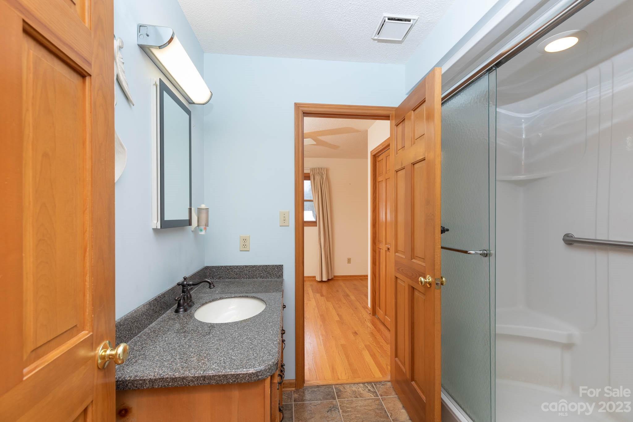 7869 Cherry Point Drive Denver, NC 28037 - Photo 16 of 38 a bathroom with a granite countertop sink and a mirror