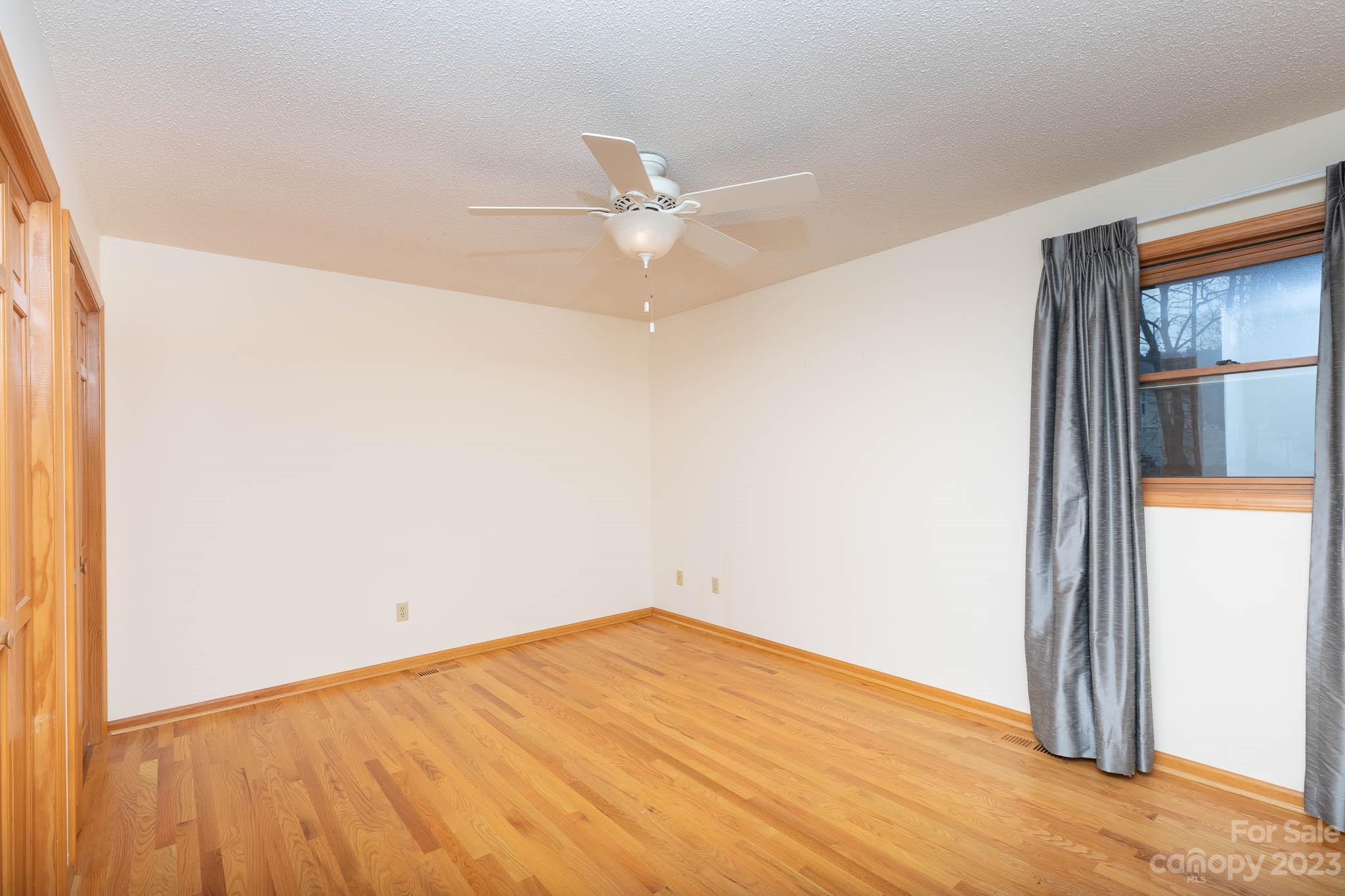 7869 Cherry Point Drive Denver, NC 28037 - Photo 19 of 38 an empty room with a window and a ceiling fan