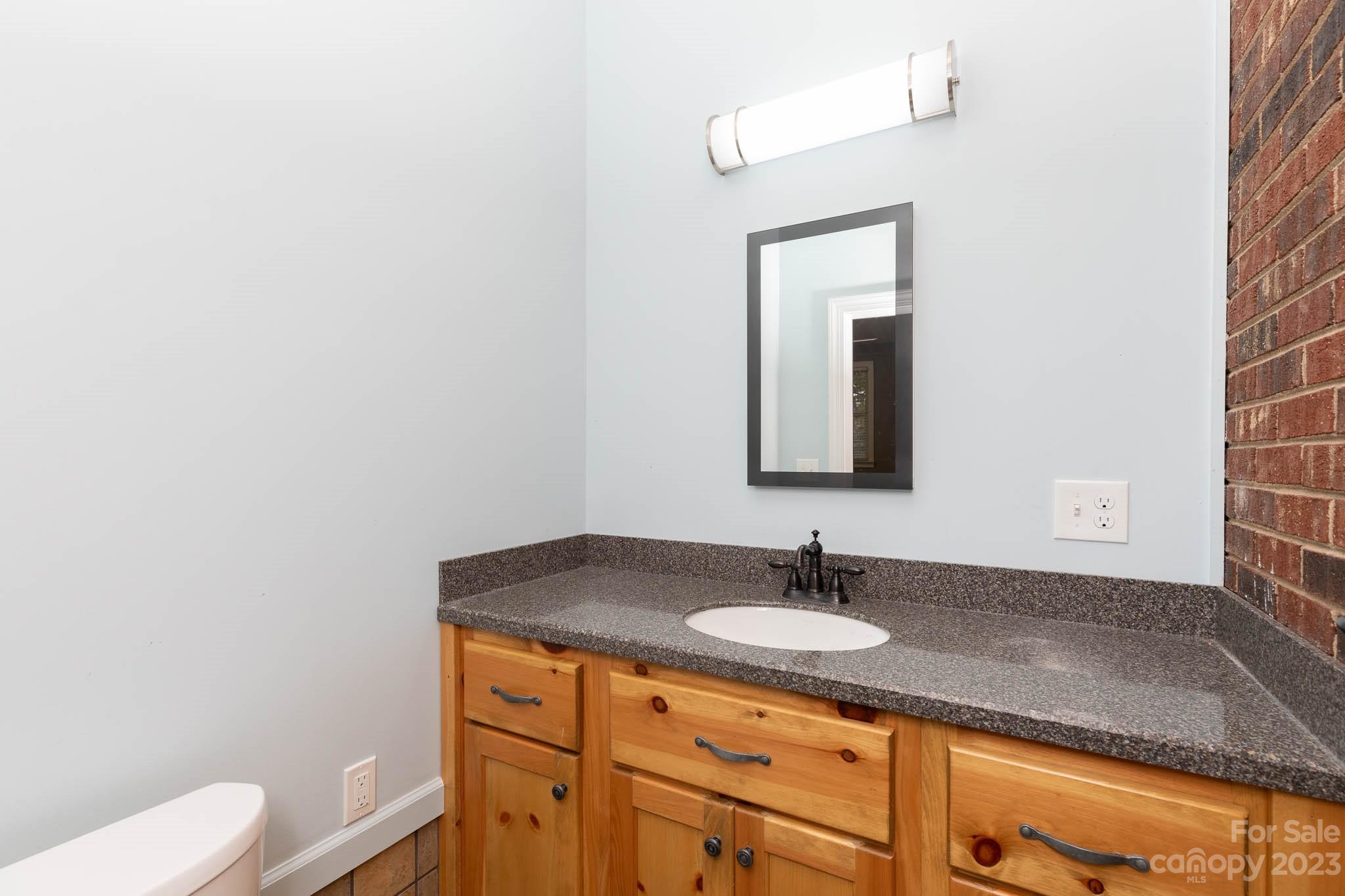 7869 Cherry Point Drive Denver, NC 28037 - Photo 27 of 38 a bathroom with a granite countertop sink and a mirror
