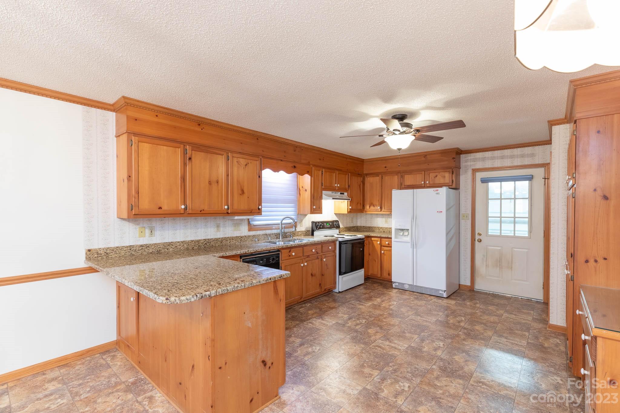 7869 Cherry Point Drive Denver, NC 28037 - Photo 3 of 38 a kitchen with a stove a refrigerator and a sink with cabinets