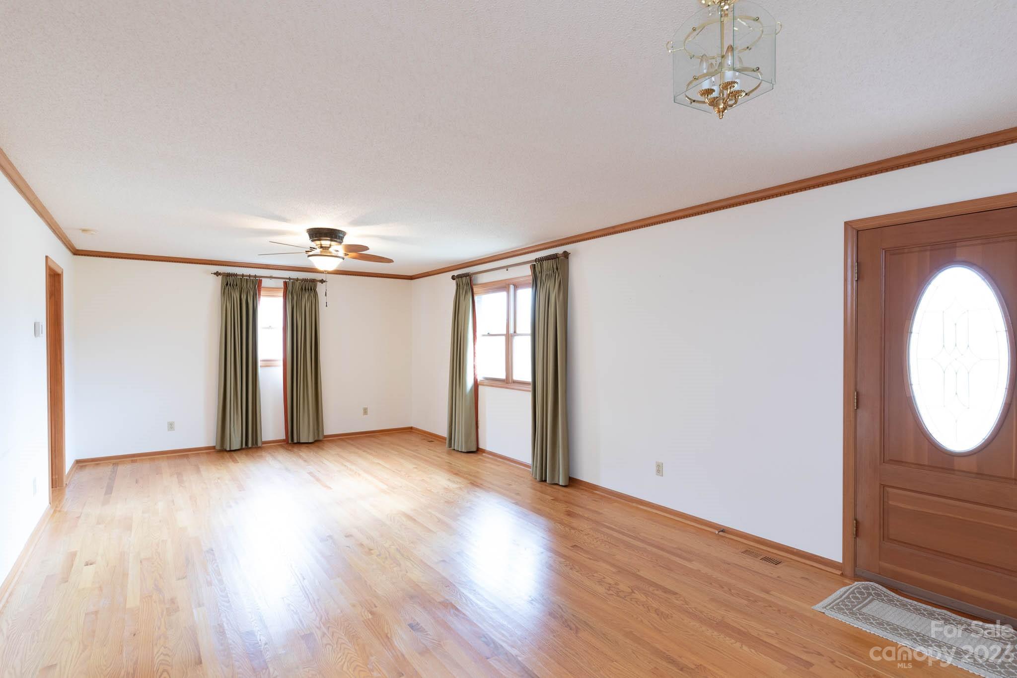 7869 Cherry Point Drive Denver, NC 28037 - Photo 7 of 38 an empty room with wooden floor mirror and windows