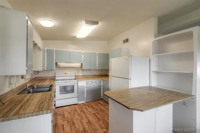 a kitchen with a refrigerator a stove top oven a sink and dishwasher
