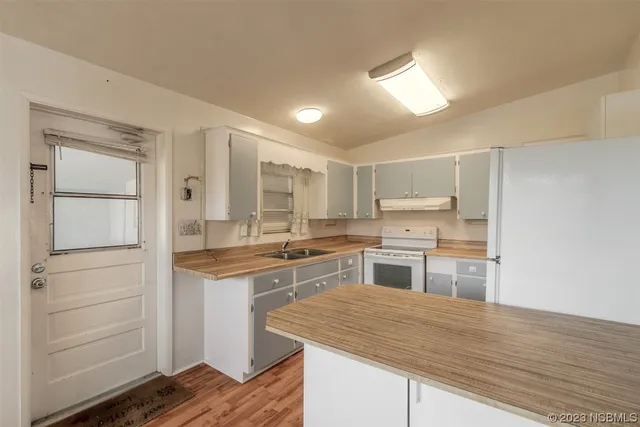 a kitchen with a stove cabinets and wooden floor