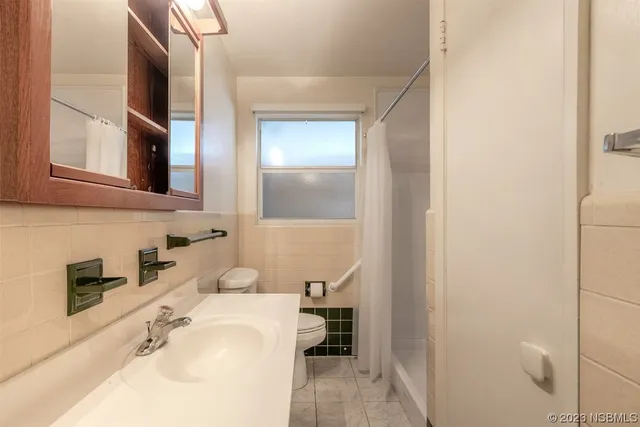 a bathroom with a sink a toilet and a mirror