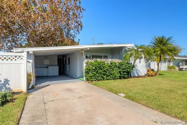 a view of a house with a yard and potted plants