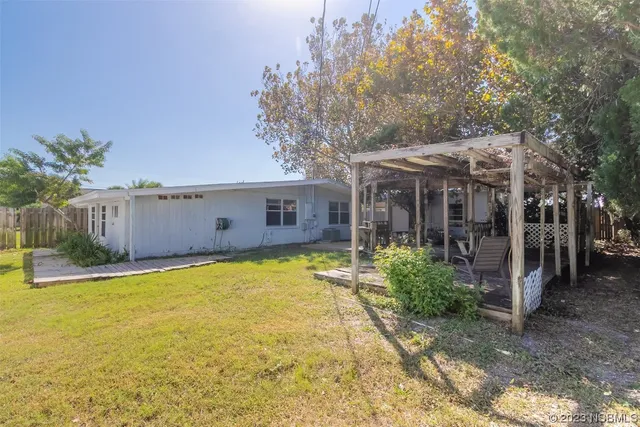 a view of a house with backyard and tree