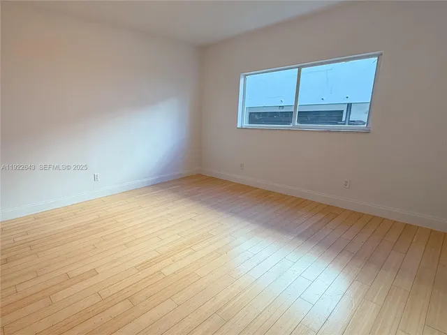 an empty room with wooden floor and closet