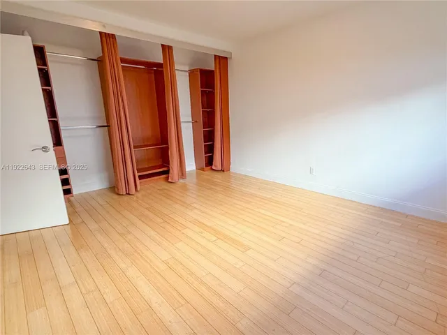 an empty room with wooden floor and closet