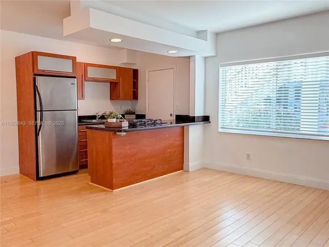 a view of kitchen with stainless steel appliances granite countertop cabinets and wooden floor