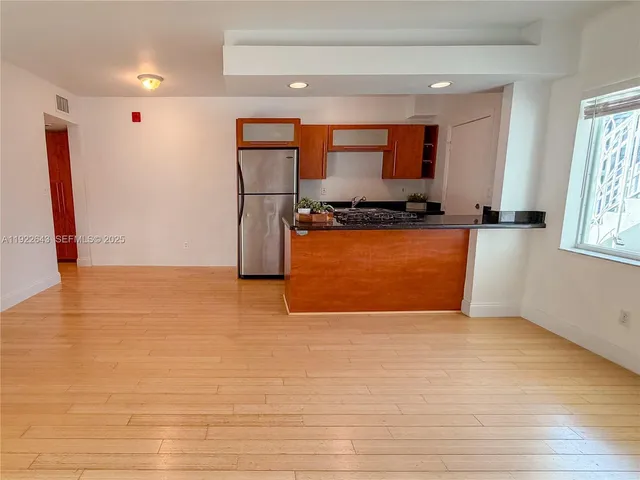 a kitchen with stainless steel appliances granite countertop a refrigerator a stove and a sink