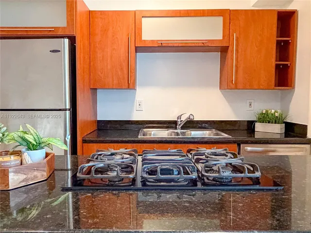 a kitchen with stainless steel appliances granite countertop a sink stove and refrigerator