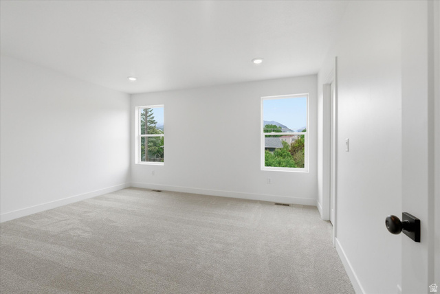 844 North 400 West Logan, UT 84321 - Photo 20 of 43 Spacious room featuring light gray carpeting, crisp white walls, recessed ceiling lighting, and two windows offering a mountain backdrop