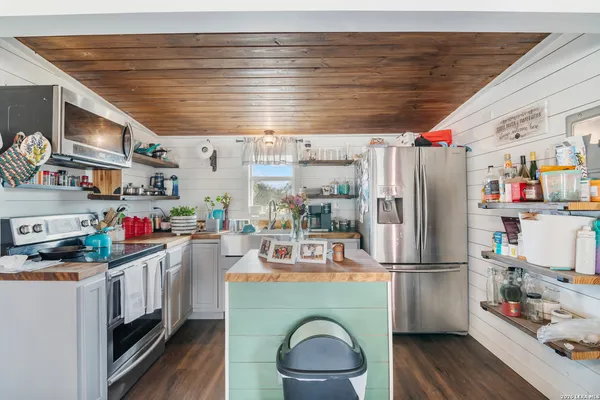 a kitchen with refrigerator and wooden floor