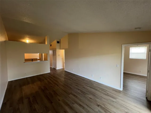 a view of an empty room and wooden floor