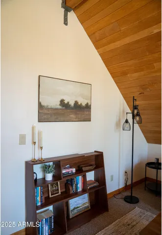 a living room with baby crib and a wooden floor