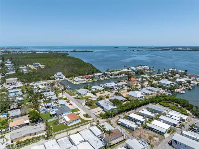 an aerial view of a city with ocean view in back
