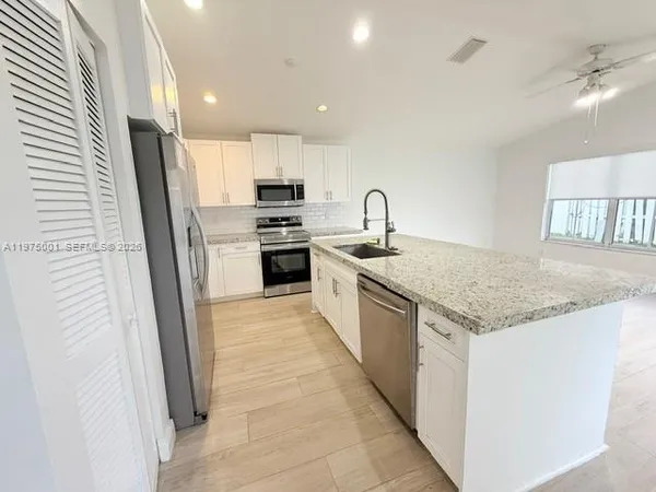 a kitchen with stainless steel appliances granite countertop a sink stove and refrigerator