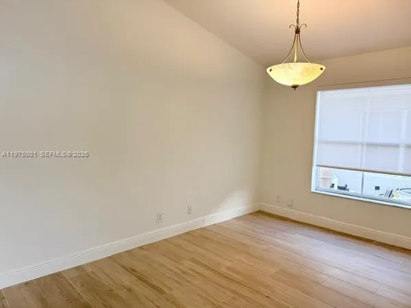a view of a room with wooden floor and a window
