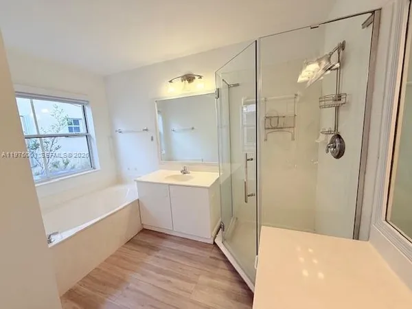 a bathroom with a tub sink shower and mirror