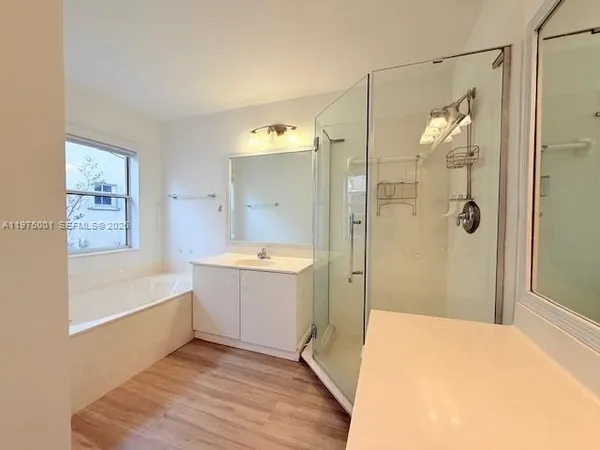 a bathroom with a tub shower and sink