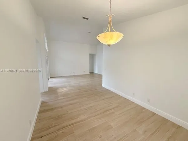 a view of a room with a wooden floor and a window