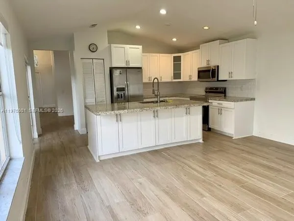 a kitchen with stainless steel appliances a sink a stove a refrigerator and cabinets
