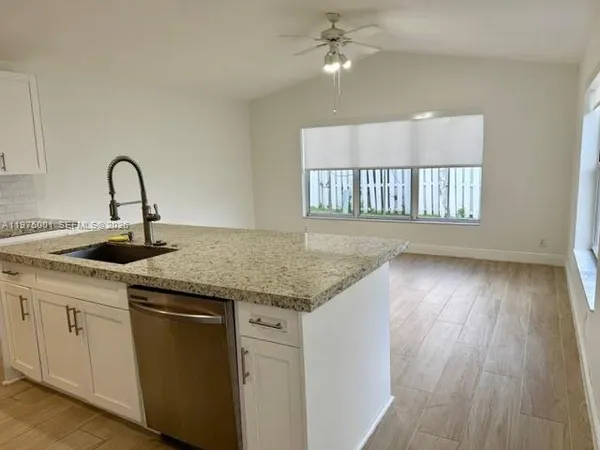 a kitchen with a sink cabinets and wooden floor