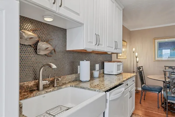 a kitchen with granite countertop a sink a stove and cabinets