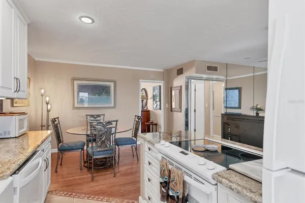 a living room with stainless steel appliances granite countertop furniture and a kitchen view