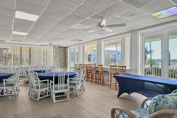 a dining room with furniture large windows and a chandelier
