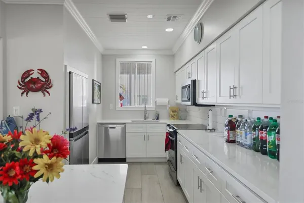 a kitchen that has a lot of cabinets a sink and appliances in it