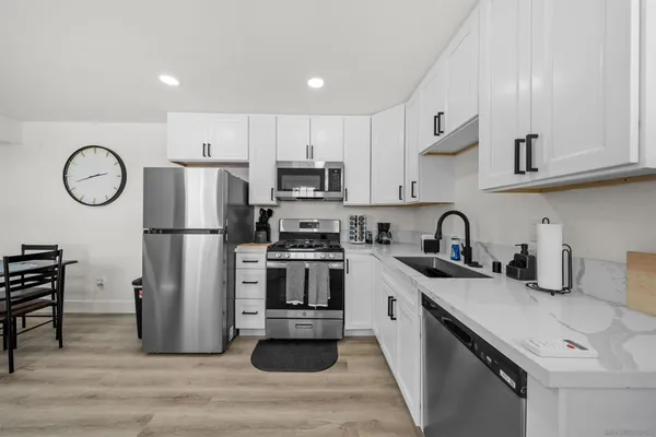 a kitchen with a refrigerator a stove a sink and cabinets