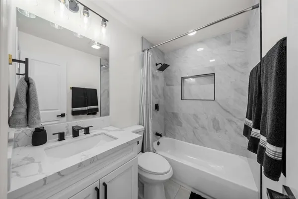 a bathroom with a tub sink toilet a mirror and shower