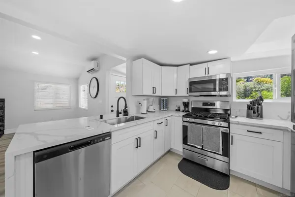 a kitchen with granite countertop white cabinets and white appliances