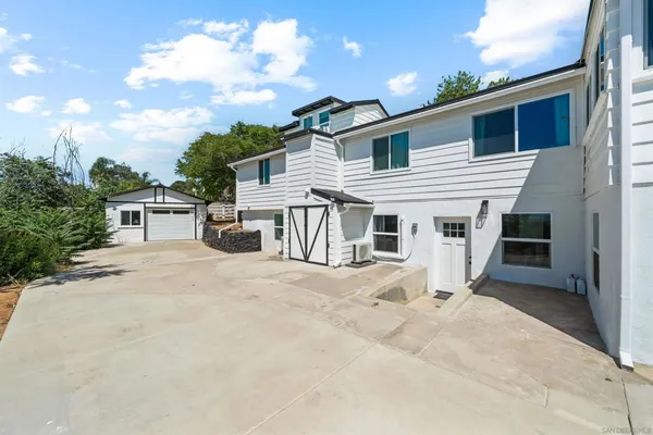 a view of a white house with a patio