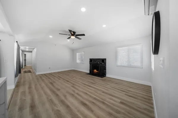 a view of an empty room with a fireplace and a window