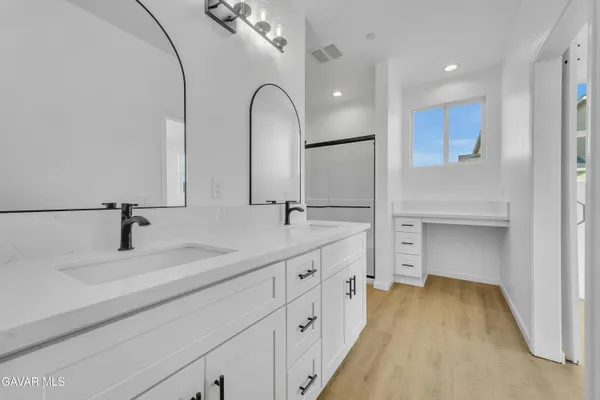 a bathroom with double vanity and a mirror