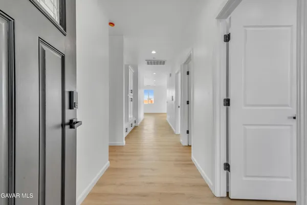 a view of a hallway with wooden floor and a glass door