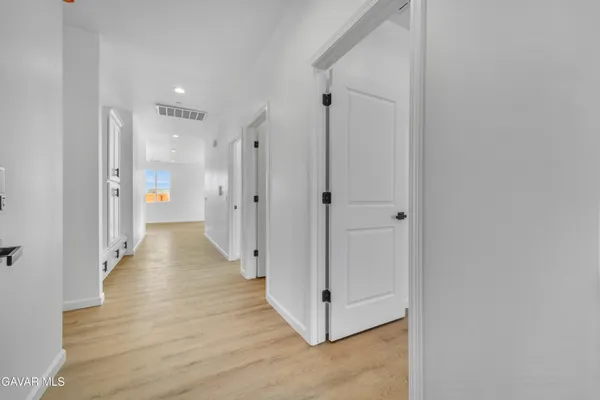 a view of a hallway with wooden floor