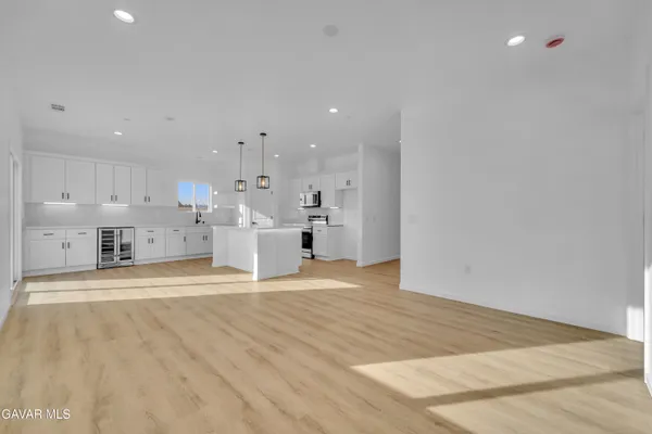 a view of kitchen with kitchen island sink and refrigerator