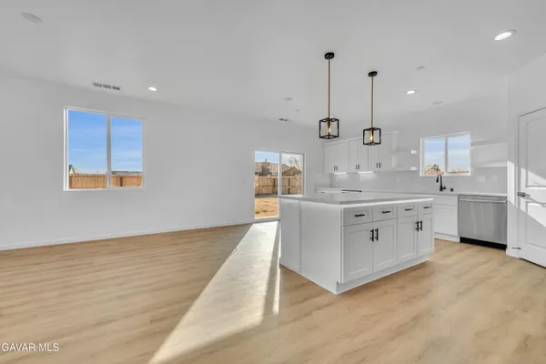 a large white kitchen with kitchen island a sink a stove and a refrigerator