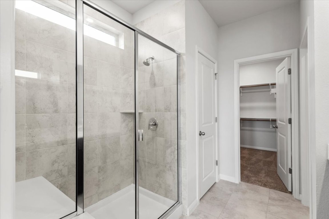 105 Otella Street Georgetown, TX 78628 - Photo 15 of 31 a bathroom with a glass shower door