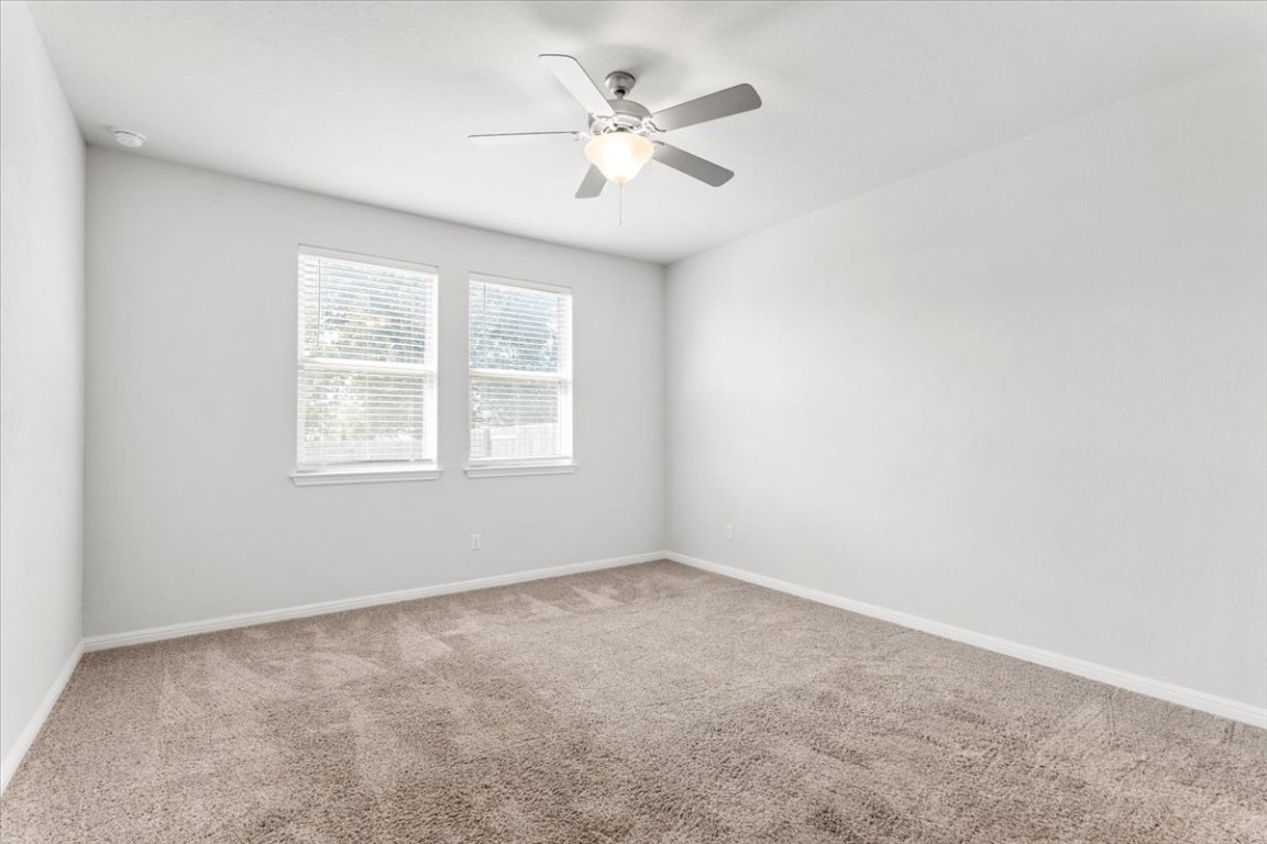 105 Otella Street Georgetown, TX 78628 - Photo 16 of 31 an empty room with windows and ceiling fan