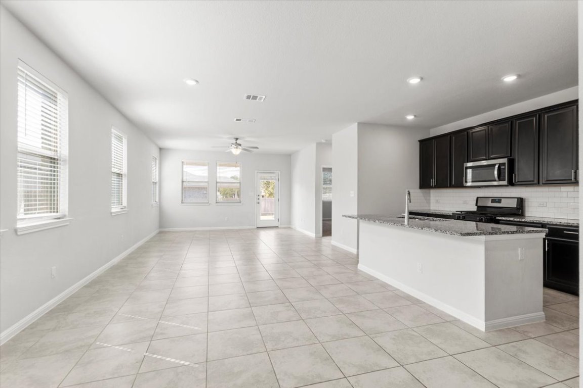 105 Otella Street Georgetown, TX 78628 - Photo 4 of 31 a view of a kitchen with a sink and a stove top oven