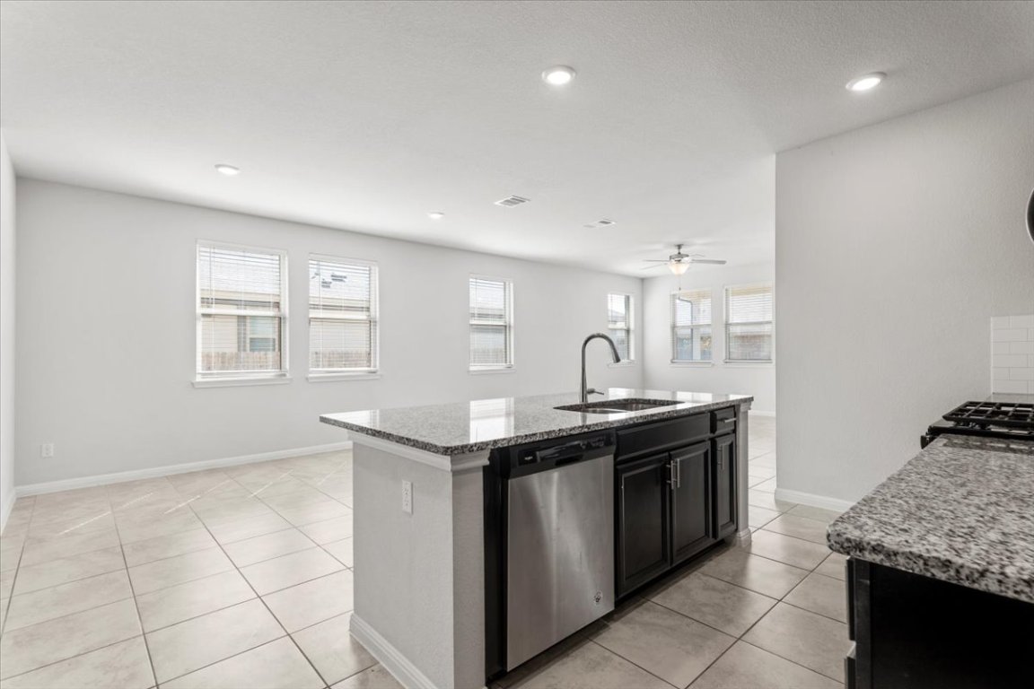 105 Otella Street Georgetown, TX 78628 - Photo 7 of 31 a kitchen with stainless steel appliances granite countertop a sink and a stove
