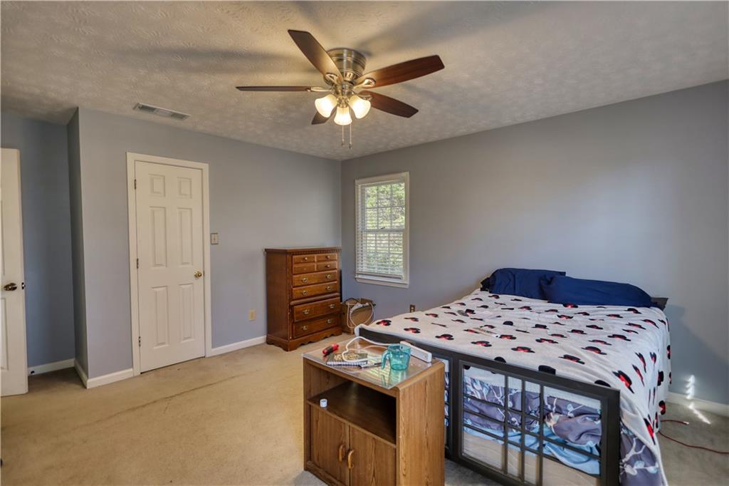 12510 Highway 36 Covington, GA 30014 - Photo 17 of 31 a bedroom with a bed and a chandelier